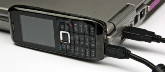 6131538-photo-concept-phone-connected-to-laptop-via-usb-cable